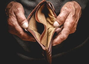 A photo showing the hands of an elderly man opening an empty wallet.