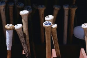 A photo of many baseball bats organized in bins for batboys and players.