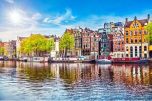 A photo showing row houses along a canal in Amsterdam, Netherlands.