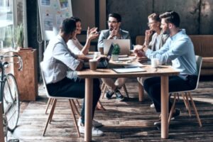 A group of employees gathering around a table holding a productive and engaging meeting.