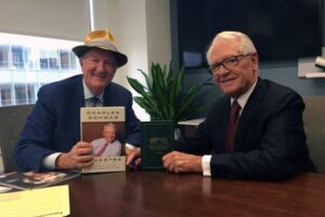 A photo of Mark Skousen and Charles Schwab exchanging their books.