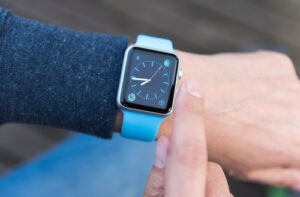 A photo of a person checking the blue Apple Watch on their wrist.