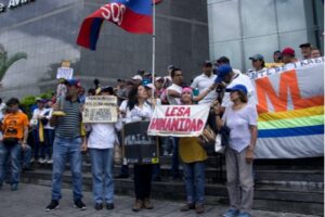 A photo of individuals carrying signs and flags in protest of Venezuelan president Nicolás Maduro.