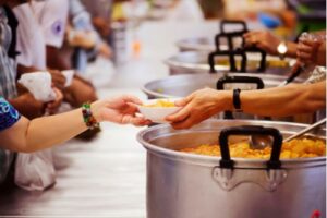 A photo showing volunteers serving food at a soup kitchen.