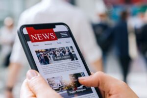 A photo showing a person viewing a news website on their smartphone.