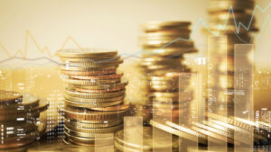 A photo showing gold coins double-exposed over a financial chart.