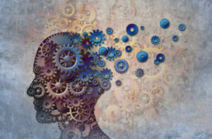 An abstract image showing a silhouette of a human head with many gears working.