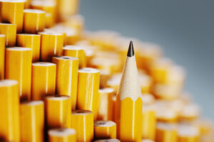 A photo showing a single sharpened pencil standing out amongst a collection of unsharpened ones.