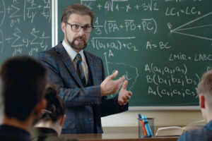 A photo showing a math professor in front of a chalkboard teaching a class.