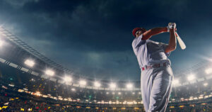 A photo of a baseball batter swinging at the plate in front of a large crowd.