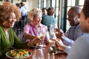 A photo showing a group of friends enjoying dinner and wine at a restaurant.