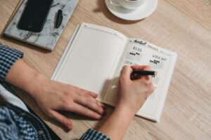 A photo showing a person using a habit tracker in their journal.