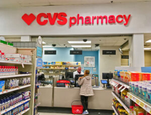 A woman picks up her prescription at a CVS pharmacy