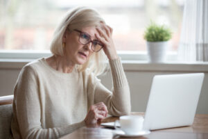 A woman working on her laptop looks frustrated and confused