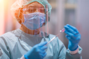 A lab technician holds a vaccine vial