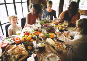 A photo showing a happy family gathered around a table for Thanksgiving dinner.