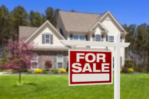 A home with a “for sale” sign in the front yard