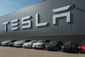 A row of Tesla vehicles outside of an assembly plant