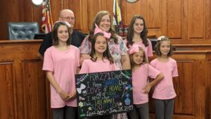 A photo showing Monica and Robert Kinder with their five adopted children.