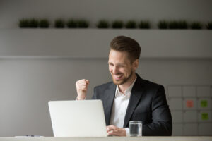 A businessman smiles at his laptop