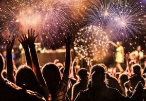 A crowd celebrates the new year with fireworks