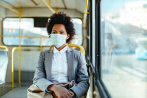 A woman wears a mask while riding the bus