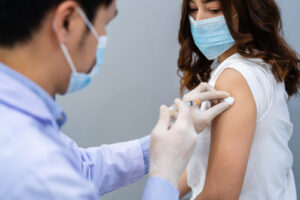 A doctor injects a COVID-19 vaccine into a patient