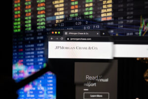 Image of the JPMorgan Chase logo as seen on a computer screen through a magnifying glass.