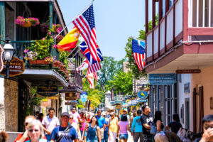 A photo showing a busy street full of shoppers lined with many businesses displaying American flags.