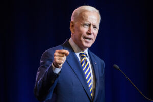 President Joe Biden speaks into a microphone