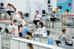 A group of patients and healthcare providers are pictured at a vaccination center.