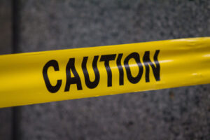 A photo of yellow caution tape across a dark background.