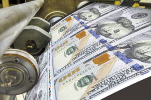 A photo showing a money printing press running $100 bills.