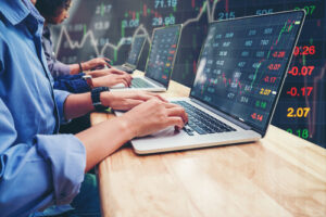 A photo showing a team of people performing market analysis on laptops.