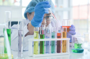 A photo showing a female scientist in protective gear working on research in a laboratory.