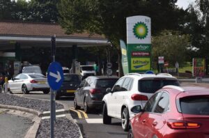 A photo showing a long line of cars waiting to purchase fuel at a gas station in England.