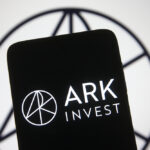 A photo illustration of the Ark Invest LLC logo on a black iPhone screen