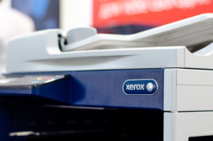 A close-up photo of the blue and white Xerox logo on the side of the company’s copy machine.