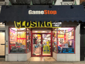 A photo of a GameStop storefront with a large yellow “Closing” banner above the entrance.