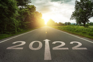 A photo of a country road at sunset with 2022 written on the asphalt