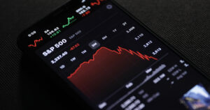 A photo of an iPhone with a chart of the S&P 500 on the screen depicting a major dip