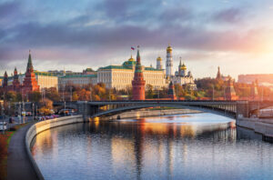 A photo of a fortified complex in the center of Moscow called Kremlin, overlooking the Moskva River at sunset.