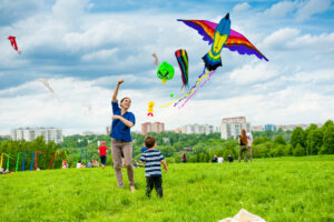 A photo of a mother flying a kite with her child on a sunny day at the park.