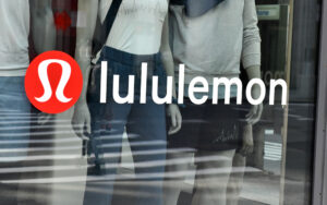 A photo of the Lululemon logo on the window of a storefront.