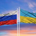 A photo of Ukraine’s and Russia’s flags in front of a blue sky