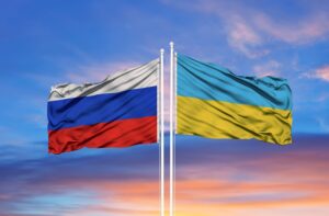 A photo of Ukraine’s and Russia’s flags in front of a blue sky