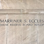 Sign that reads “Marriner S. Eccles” at the entrance of the Federal Reserve Board headquarters building.