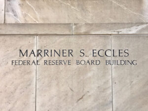 Sign that reads “Marriner S. Eccles” at the entrance of the Federal Reserve Board headquarters building.