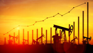 Oil rigs at sunset with an illustrated bar chart and line graph over top.