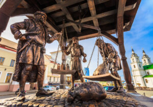 A photo of the bronze statue of trade merchants weighing their payment on a scale located in Minsk, Belarus.